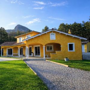 a yellow house with a gravel driveway at Bastide des Civayeres in Veynes