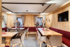 a restaurant with wooden walls and tables and chairs at Hotel Alpenstolz - Culinary Hideaway Stubai in Mieders