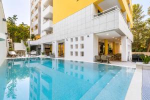 a swimming pool in front of a building at Hotel Antonio in Makarska