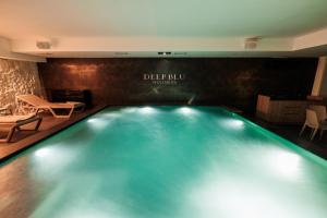 une piscine éclairée dans une chambre d'hôtel dans l'établissement Deep Blu Boutique Hotel, à Żurrieq