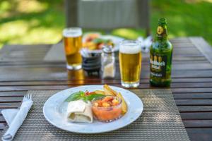 a table with a plate of food and two glasses of beer at Mziki Safari Lodge in Vaaldam