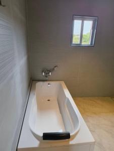 a white bath tub in a room with a window at Berry Fresh Stays Mahabaleshwar With Pool in Mahabaleshwar +46 photos