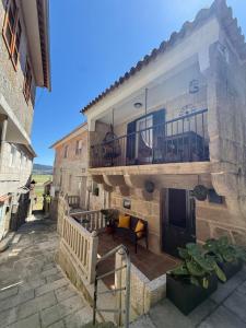 a stone house with a balcony and a patio at El Rincón de Mateo in Combarro