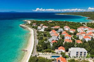 an aerial view of a resort next to the beach at Bumblebee apartments & rooms with pool in Novalja