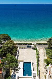an aerial view of a swimming pool next to the ocean at Bumblebee apartments & rooms with pool in Novalja