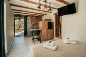a bedroom with two beds and a kitchen with a table at Ellafos Traditional Living-Elafonisi Couples Retreat in Elafonisi