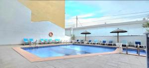 a large swimming pool with chairs and umbrellas at Hotel Teide in El Arenal