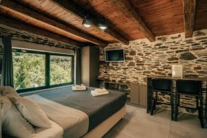 a bedroom with a large bed and a stone wall at Ellafos Traditional Living-Elafonisi Couples Retreat in Elafonisi