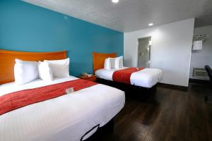 two beds in a hotel room with blue walls at M Star Hotel Searcy in Searcy
