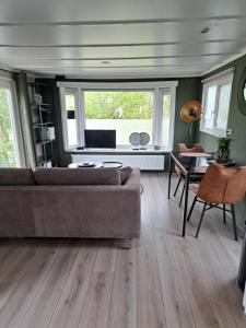 a living room with a couch and a table at Camping de Zandhorst, Chalet Madera in Wouterswoude
