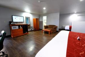 a hotel room with a bed and a flat screen tv at M Star Hotel Searcy in Searcy