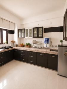 a kitchen with black cabinets and a counter top at Hotel Shreenathji Inn in Jāmb