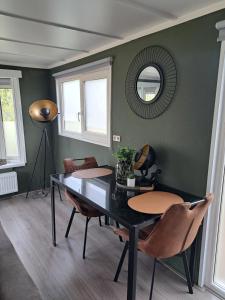 a dining room with a table and chairs and a mirror at Camping de Zandhorst, Chalet Madera in Wouterswoude