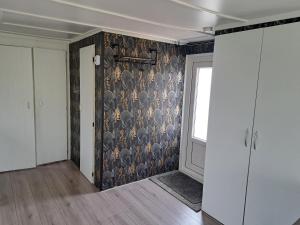 a room with a wall with a wallpaper with birds on it at Camping de Zandhorst, Chalet Madera in Wouterswoude