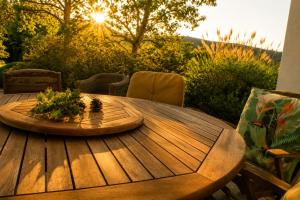 a wooden table with a centerpiece on a patio at La Bergerie de Losse in Traize
