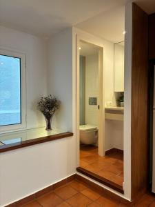 a bathroom with a toilet and a vase of flowers at Loft con encanto in Cadaqués