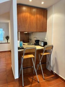 a kitchen with a counter and two stools in it at Loft con encanto in Cadaqués