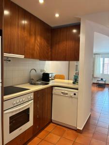 a kitchen with wooden cabinets and a white stove top oven at Loft con encanto in Cadaqués