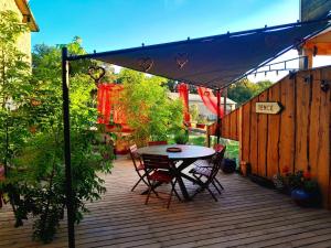 a patio with a table and chairs on a deck at La Belle Tençoise in Tence