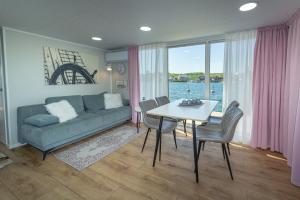 a living room with a couch and a table with chairs at Hausboot Lydia in Gager in Gager