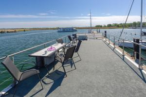 a dock with a table and chairs on a boat at Hausboot Lydia in Gager in Gager