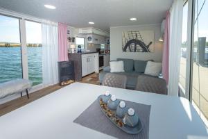 a kitchen and a living room with a view of the ocean at Hausboot Lydia in Gager in Gager +25 photos