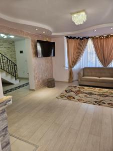 a large living room with a couch and a television at Vila Pângărați in Pangarati