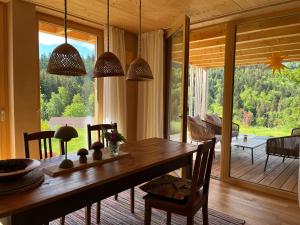 a dining room with a wooden table and a large window at Ferienwohnung am Stadtwald in Triberg