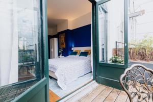 a bedroom with blue walls and a bed on a balcony at Aparthotel Jacques van Marken Erfgoed in Delft