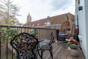 a balcony with two chairs and a fence at Aparthotel Jacques van Marken Erfgoed in Delft