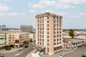 a tall white building on a city street at Hotel Egreta in Tulcea