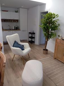 a living room with a white chair and a plant at Il rifugio del cuore in San Massimo