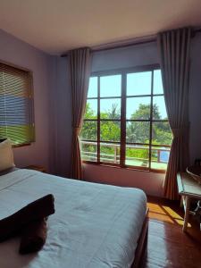 a bedroom with a bed and a large window at Amber Koh Rong in Koh Rong Island