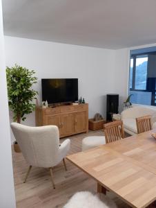a living room with a television and a table and chairs at Il rifugio del cuore in San Massimo