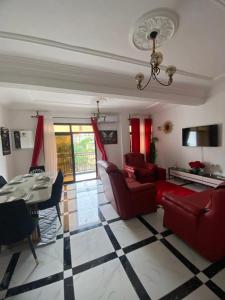 a living room with red couches and a table at Lita résidence in Yaoundé