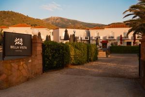 a sign in front of a building with a resort at HOTEL BELLA VISTA in Mythimna