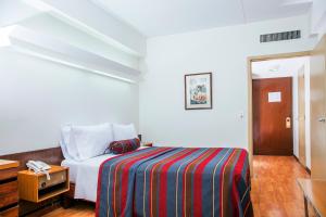 a bedroom with a bed with a striped blanket at San Agustin Riviera in Lima