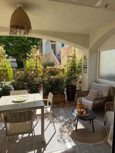 a patio with a table and chairs and a couch at Studio cosy a 500m de la plage in Fréjus