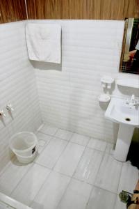 a white bathroom with a toilet and a sink at Shangrella Hotel Malam Jabba in Malam Jabba