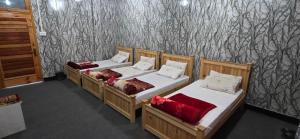 a group of four beds in a room at Shangrella Hotel Malam Jabba in Malam Jabba