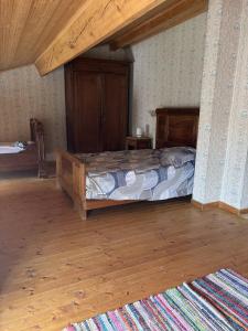 a bedroom with a bed and a wooden floor at La Digeonne in Chabeuil