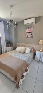 a bedroom with a large bed and a fan at logement ensoleillé in Cardet
