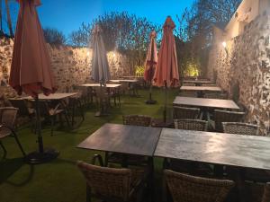 a restaurant with tables and chairs with umbrellas at Le MUSTANG in Saint-Geniez-dʼOlt