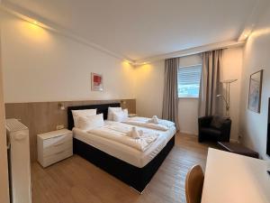 a hotel room with a bed and a chair at Hotel Mozart in Traunreut