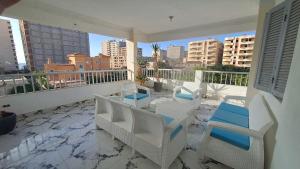 a balcony with white chairs and a view of the city at Ruim apartement abo saeed in El Delr