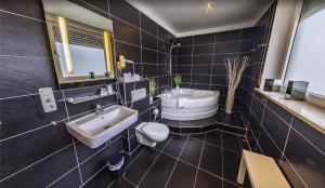 a bathroom with a sink and a toilet and a tub at Hotel Mozart in Traunreut +16 photos