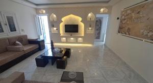 a living room with a couch and a tv at Ruim apartement abo saeed in El Delr