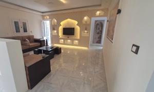 a living room with a couch and a television at Ruim apartement abo saeed in El Delr