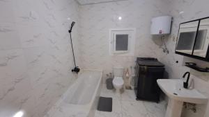 a white bathroom with a tub and a sink at Ruim apartement abo saeed in El Delr +21 photos