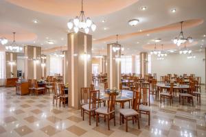 a dining room with tables and chairs and chandeliers at Hotel Traian in Brăila